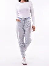 Jeans de mujer color negro lavado, tiro alto, con corte recto o ligeramente cónico y largo al tobillo.