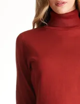 Polera tejida en hilado fino color verde oscuro, de manga larga con tajo en el puño y cuello alto.