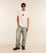 Pantalón de jean celeste de corte super baggy con cintura con trabilla, cierre tradicional, bolsillos y detalles deshilachados.