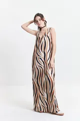 Vestido largo con estampado abstracto en tonos marrón, negro y blanco, escote en V y corte suelto.