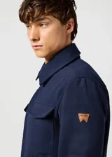 Campera Wrangler azul marino de paño con cuello clásico, cierre frontal con botones a presión, cuatro bolsillos frontales con solapa y puños con botón.