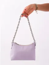 Cartera de cuero color lila con correa de cadena plateada, cierre superior y forro interior con bolsillo.