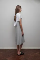 Vestido midi gris de viscosa, con corte evasé, mangas cortas y escote redondo.