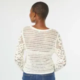 Sweater color beige de ganchillo con mangas largas.