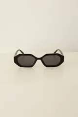 Lentes de sol con marco hexagonal de color negro y cristales oscuros. Cuentan con protección UV400 y están fabricados en policarbonato. Incluyen estuche.