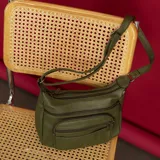 Bandolera color beige de símil cuero con dos bolsillos frontales con cierre, doble apertura superior con cierre, un bolsillo trasero con cierre y dos bolsillos internos. Incluye correa de galón larga regulable para llevar al hombro.