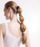 Set de cuatro gomitas de pelo gruesas y texturizadas, en colores negro, ocre, naranja y beige.