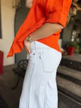 Pantalón de jean wide leg color blanco, tiro alto, con bolsillos delanteros y traseros.