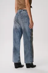 Pantalón de jean azul con estampado de zorros en tonos marrones.