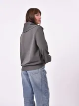 Buzo gris con cierre de cremallera en el cuello, de mangas largas y diseño holgado.