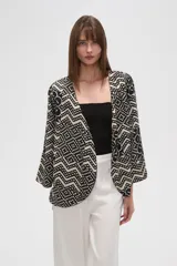 Kimono de poliéster con estampado geométrico en blanco y negro, mangas 3/4, corte holgado y cuello en V.