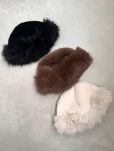 Gorro de piel sintética color negro, con forma redondeada y ala corta.