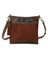 Cartera bandolera de cuero marrón con panel central de cuero con pelo color marrón y costuras a la vista.