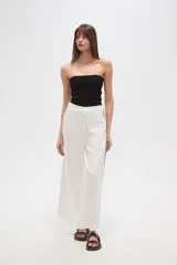 Pantalón blanco de viscosa, corte ancho y tiro alto, con detalle de bordado calado negro en los laterales.