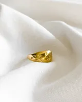 Anillo dorado de acero con diseño de estrellas y círculos.