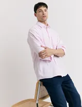 Camisa de vestir de algodón color rosa claro, de corte clásico, manga larga y cuello italiano. Cierre frontal con botones a tono.