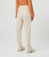 Pantalón zanahoria color crema con textura de cuadros, cordón ajustable en la cintura, bolsillos delanteros y traseros.