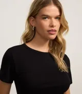 Blusa color beige de viscosa con elastano, de manga corta, cuello redondo, textura acanalada y bajo ondulado.