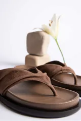 Sandalias de cuero color verde oliva, con tira ancha superior con detalle de frunce y suela plana.