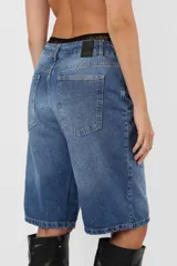 Bermuda de jean rígido, tiro medio, calce relax y proceso de lavado artesanal.