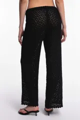 Pantalón blanco de tejido calado con cintura elástica y cordón ajustable.