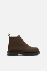 Bota de caña baja color marrón chocolate, de cuero gamuzado, con cordones al tono y suela track color negro.