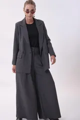 Blazer gris de lana con solapas de muesca, cierre cruzado con doble botonadura, bolsillos con solapa y corte holgado.