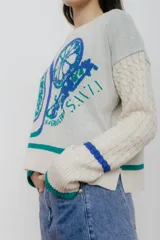 Buzo azul marino tejido en jacquard con diseño de frutas y verduras. Tiene mangas tejidas en ochos, bordado en la espalda y puños con agujerito para el dedo.