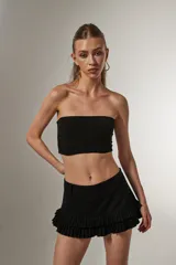 Top cropped negro de poliamida y lurex, al cuerpo, con elástico y cuello strapless.