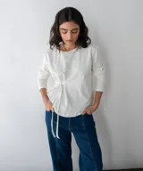 Remera blanca de manga larga con lazo en la cintura.