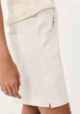 Short de vestir color lila, de corte recto, con bolsillos laterales y cierre frontal con botón y cremallera.