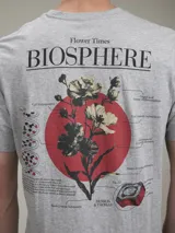 Remera de manga corta color gris jaspeado, confeccionada en algodón, con cuello redondo y estampado pequeño de corazón con flores en el pecho. Corte clásico.