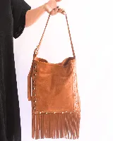 Bandolera de cuero color beige con flecos y tachas plateadas.