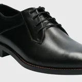 Zapato de vestir formal de cuero negro, con cordones y suela de goma.