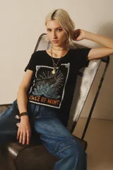 Remera negra de algodón y modal con estampa de un girasol y la frase "Peace of Mind".