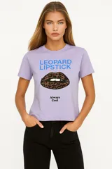 Remera de algodón color crudo con estampado de un labial rojo y texto en color bordó que dice "It's OK to wear lipstick". Corte clásico, cuello redondo y mangas cortas.