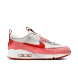 Zapatillas Nike Air Max 90 Futura de mujer, color blanco, rosa y rojo. Confeccionadas con materiales textiles y detalles de gamuza. Presentan la clásica cámara de aire visible en la entresuela y suela de goma con diseño waffle.