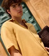 Camisa masculina de manga corta, cuello inglés y abotonado delantero, confeccionada en algodón con textura. Presenta un calce comfort más holgado.