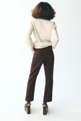 Jeans de tiro alto color marrón, corte slim fit y bootcut, con cinco bolsillos y cierre frontal con cremallera y botón.