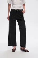 Pantalón jean negro de corte recto, tiro medio y ruedo desflecado.