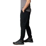 Pantalón de trekking negro con corte tapered, tejido resistente al agua y a las manchas, cintura elástica, bolsillos delanteros, bolsillo de seguridad, dobladillo elástico, entrepierna reforzada, pierna acampanada y bolsillo trasero con botón de presión.