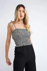 Musculosa a cuadros blanco y negro, con tirantes finos y elástico en la cintura.