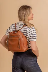 Cartera mochila color marrón de símil cuero suave con múltiples bolsillos con cierre, división al medio y correa ajustable de doble manija para llevar al hombro y como mochila.