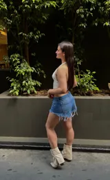 Short de jean de tiro bajo, color azul, con bolsillos delanteros y traseros, y flecos blancos en el ruedo.