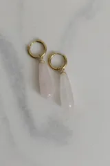 Par de aros colgantes con argolla dorada de acero quirúrgico hipoalergénico y dije en forma de gota de piedra natural blanca.