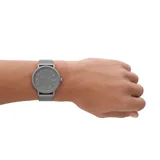 Reloj Skagen Kuppel con caja de acero inoxidable gris de 44mm, malla metálica gris de 22mm, mecanismo de cuarzo con tres agujas y sub-segundero, esfera gris con acabado arenado y cristal mineral.