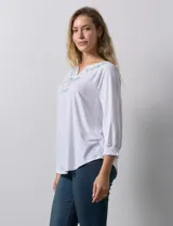 Blusa blanca de modal, marca Ruby Rd. Cuello a la base, escote en V bordado con flores. Manga ¾ amplia con puño fruncido.