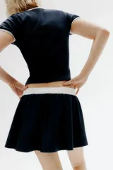 Minifalda azul marino con cintura elástica blanca y cordón ajustable.