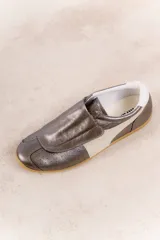 Zapatillas deportivas plateadas con detalles en blanco y suela de goma color caramelo.