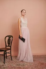 Vestido largo de fiesta color rosado con lunares blancos. Tiene cuerpo de micro tul bordado con volados en los hombros y falda de tul con forro. Incluye cinturón de raso al tono.